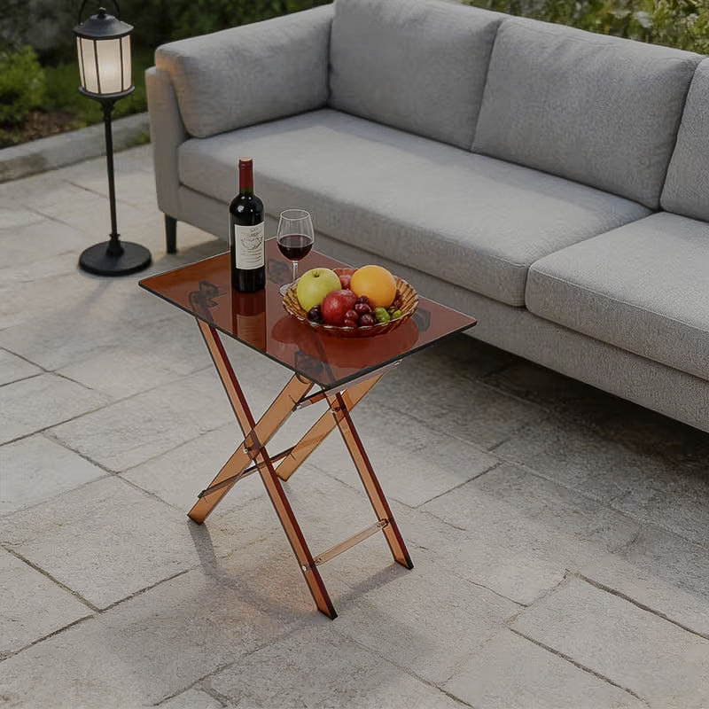 Transparent brown acrylic folding side table beside a patio sofa