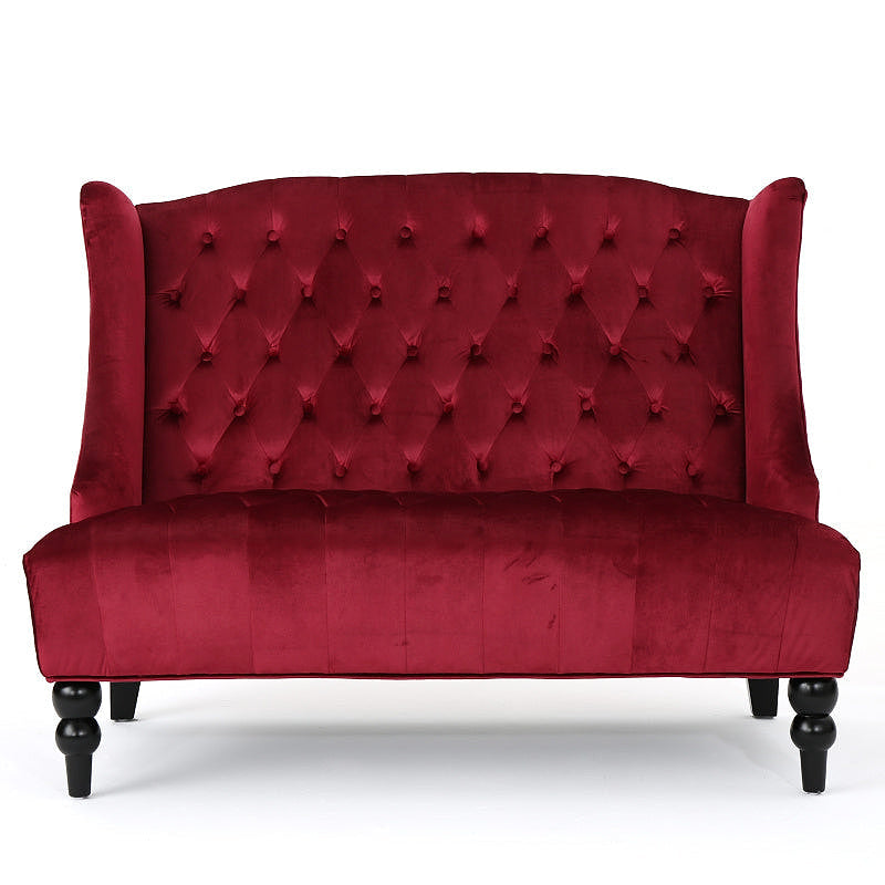 Front view of the wine red velvet loveseat with a high tufted back and turned front legs.