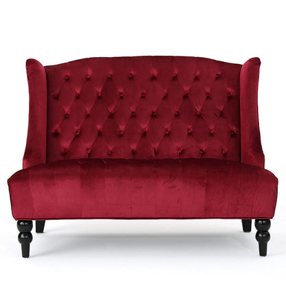 Front view of the wine red velvet loveseat with a high tufted back and turned front legs.