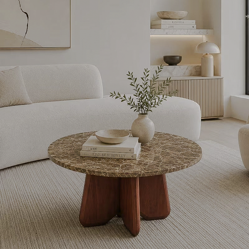 Round brown veined-top coffee table with a cross-leg base beside a cream sofa