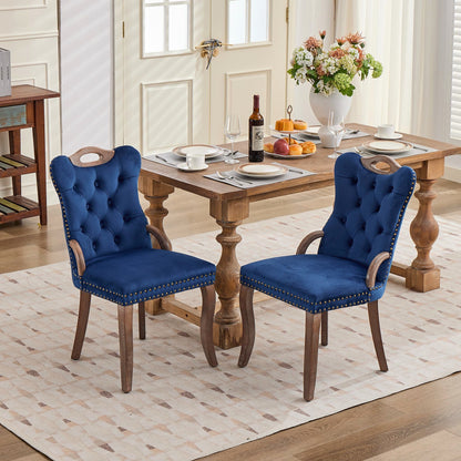 Blue velvet dining chair with a tufted back, wood handle, and curved wood legs