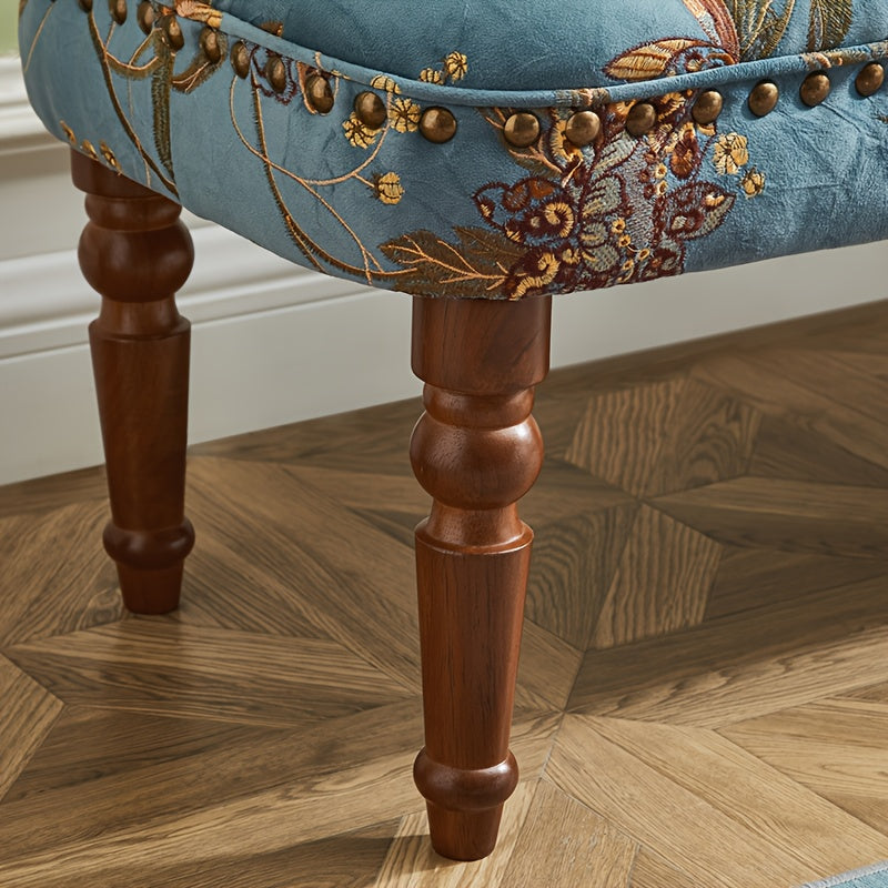 Close-up of floral upholstery nailhead trim and turned leg