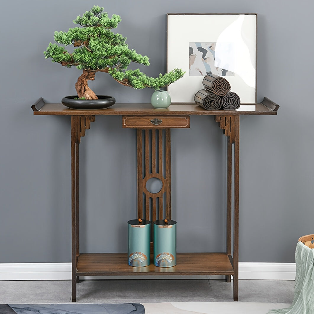 Brown bamboo console with a central drawer, geometric back detail and lower shelf against a blue-gray wall.