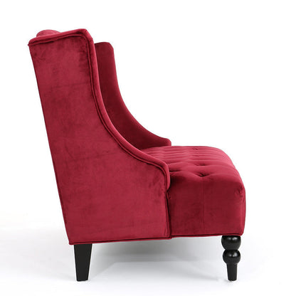 Side profile of the wine red velvet loveseat showing its curved back, upholstered seat and dark legs.
