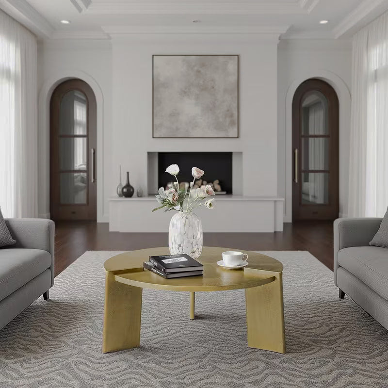 Golden round coffee table with three broad slab legs in a bright living room