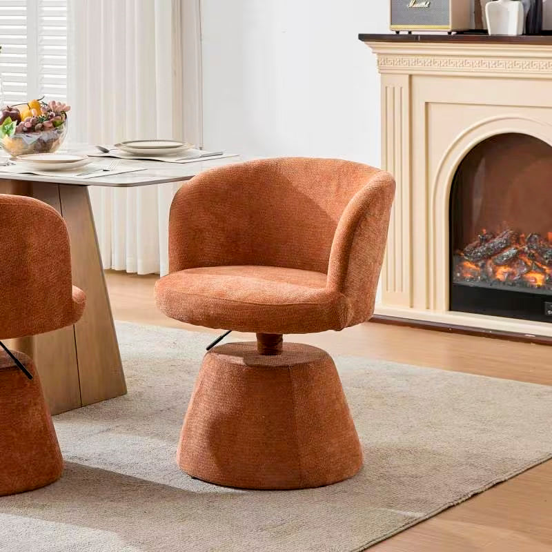 Terracotta upholstered swivel chair with curved back and tapered round pedestal base
