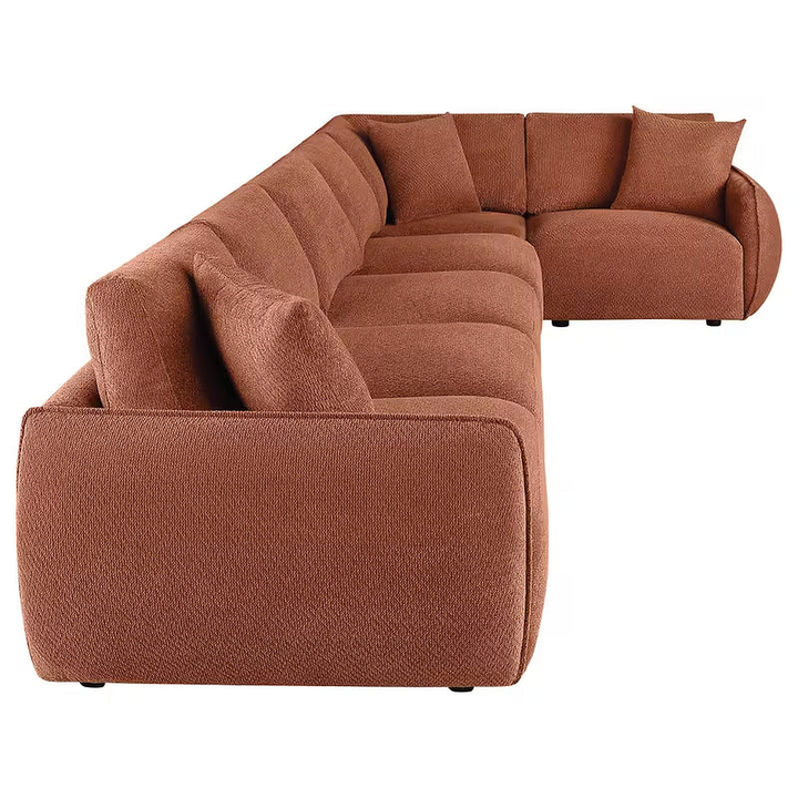 Side view of the coral Logan sectional showing its rounded arm, seat cushions and corner arrangement.